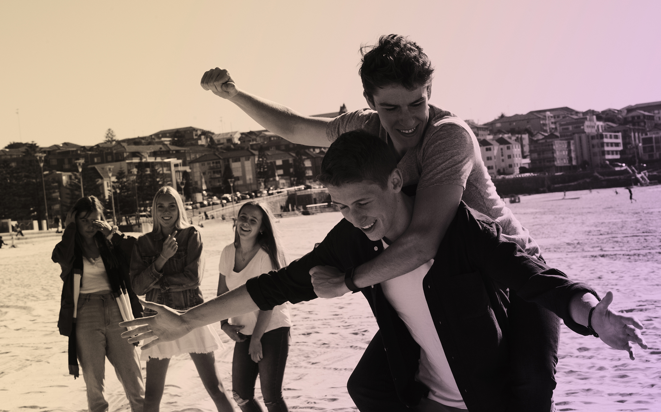 A group of young people laughing together running up a hill